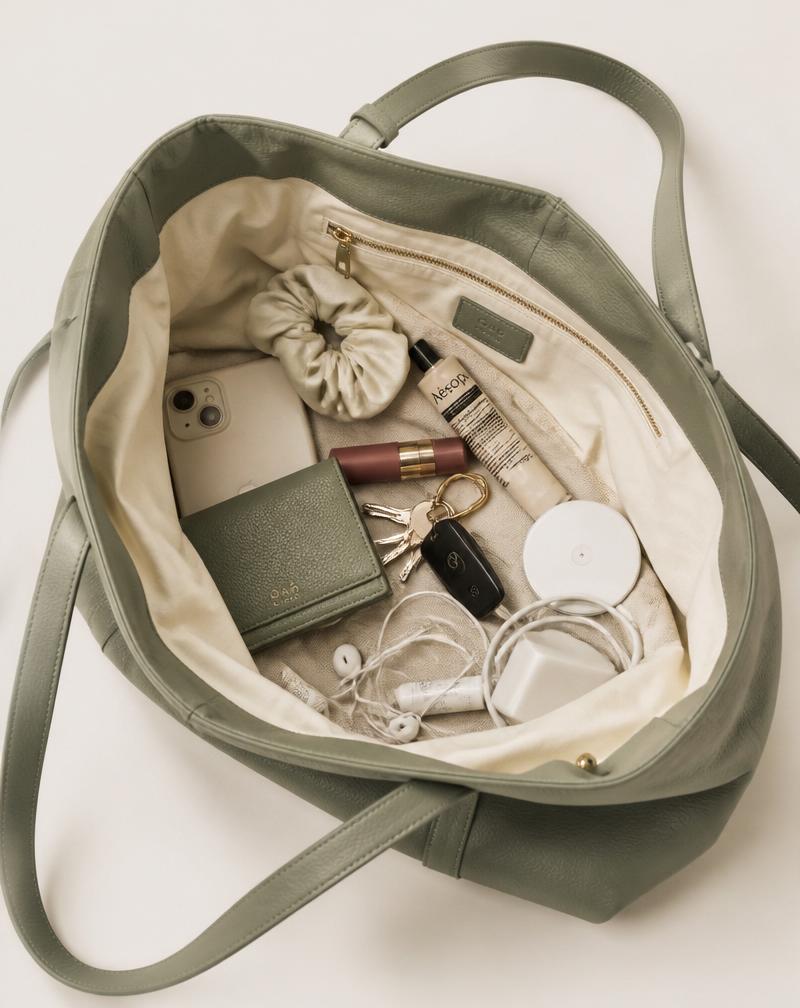 A messy tote bag interior with loose phone, keys, and cables
